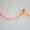 pom pom festival garland with orange and pink pom poms