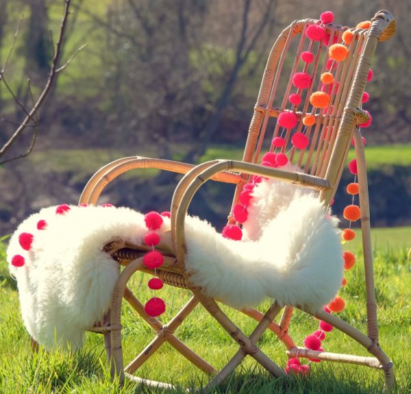 PomPom Galore Festival Orange & Pink combo neon pompoms on chair with sheepskin