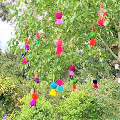 Jumbo Pom Pom and Tassel Swags 25 Jumbo pom pom tassel swags hanging in a tree
